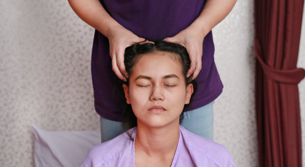 Massage therapist performing hands-on head and neck massage training