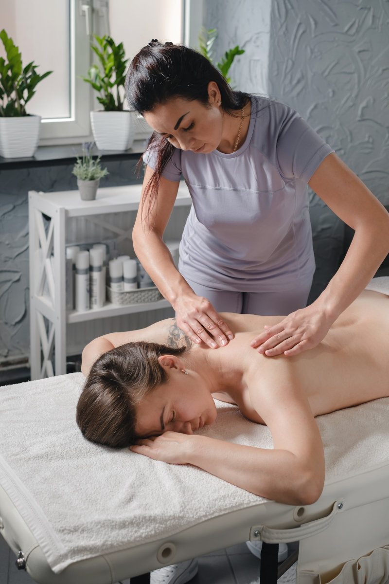 Professional massage therapist providing neck and shoulder massage